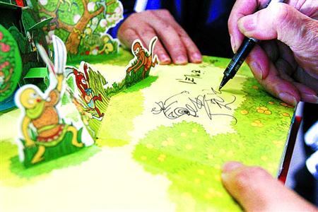 在上海童书展上，孙悟空动画形象设计者严定宪为读者签名