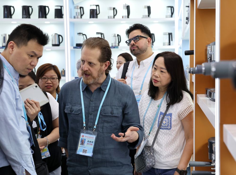 4月15日，一名境外采购商（中）在一家电器公司的展区洽谈选购。新华社记者 刘大伟 摄.jpeg