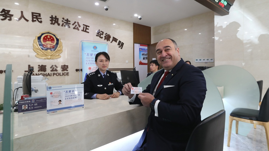 昨天，来自土耳其的伊尔马兹斯南在上海市公安局出入境管理局办证大厅展示“五星卡”。 新华社发  .jpeg