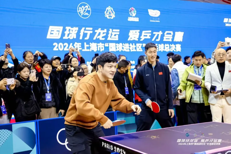 樊振东(左)和王励勤(右)与市民选手切磋球技.png 樊振东(左)和王励勤(右)与市民选手切磋球技.png