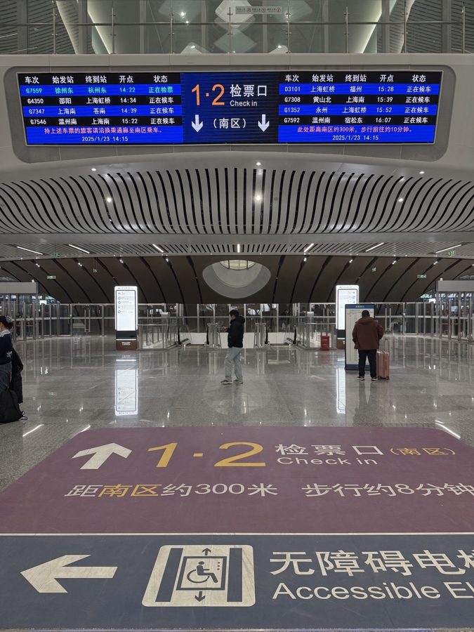 上海松江站北区检票大厅上方电子屏幕会显示南区检票口的位置，地面标识还写明了距离及步行所需时间。记者 王一凡 摄.jpg