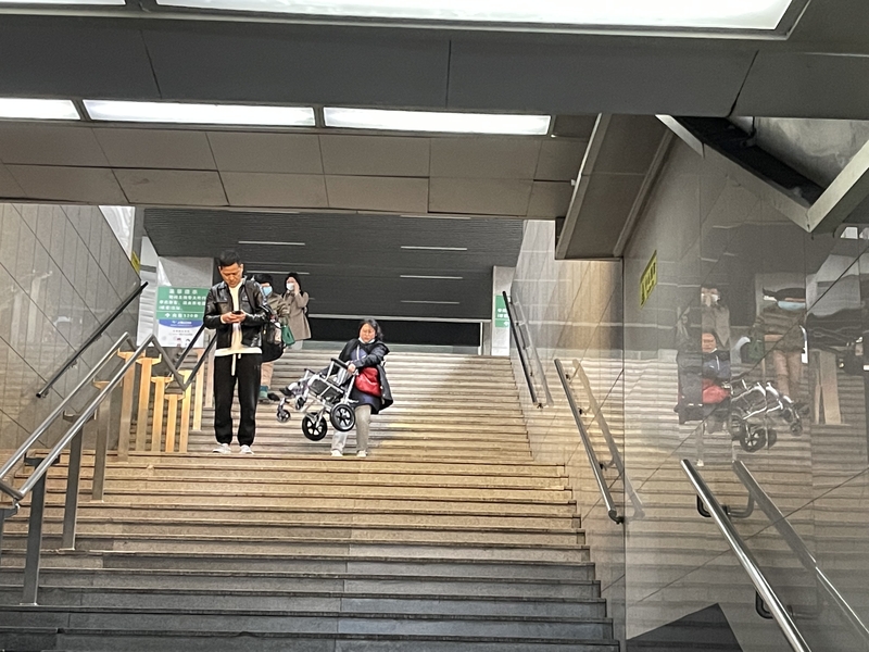 待旅客“大部队”离开后,一名女子才搬着轮椅艰难地下台阶.jpeg 待旅客“大部队”离开后,一名女子才搬着轮椅艰难地下台阶.jpeg