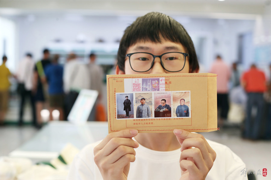 昨天,上海市民在中国邮政闸北邮政支局排队购买《纪念邓小平同志诞辰120周年》纪念邮票。图为一位年轻人在保价信封上贴上纪念邮票。记者 蒋迪雯 摄.jpg 昨天,上海市民在中国邮政闸北邮政支局排队购买《纪念邓小平同志诞辰120周年》纪念邮票。图为一位年轻人在保价信封上贴上纪念邮票。记者 蒋迪雯 摄.jpg