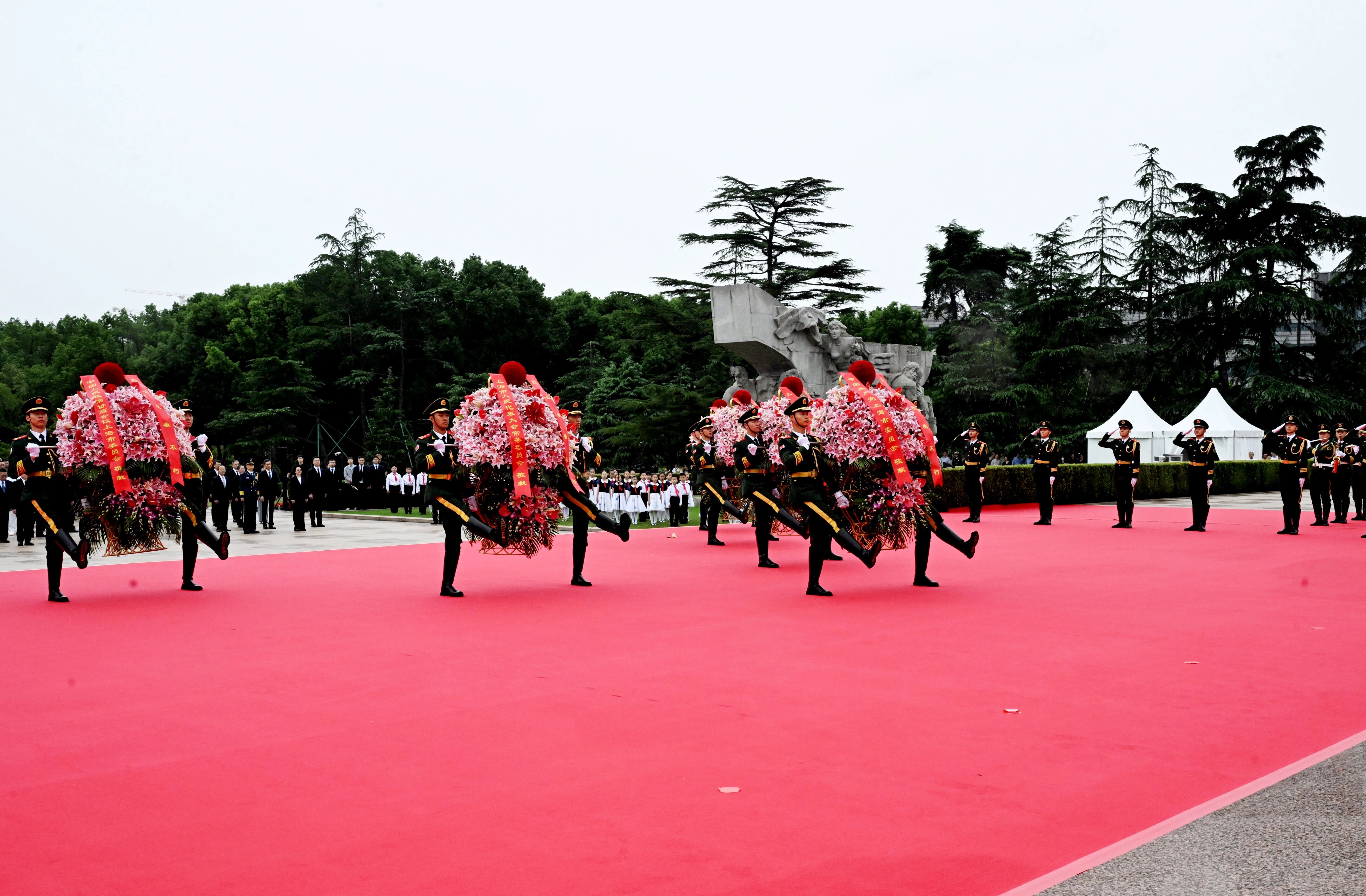 14名礼兵稳稳抬起花篮,从两侧缓步走向革命烈士纪念碑,将花篮敬放在纪念碑前.jpg
