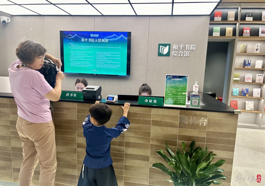 祖孙一起前来办理读者证。 均 施晨露 摄.jpeg 祖孙一起前来办理读者证。 均 施晨露 摄.jpeg