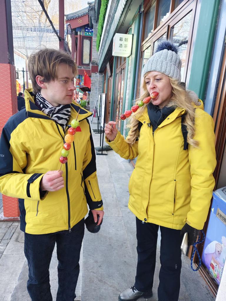 德国游客乌尔丽克与埃米尔在什刹海吃糖葫芦。新华社记者 于佳欣 摄 .jpg 德国游客乌尔丽克与埃米尔在什刹海吃糖葫芦。新华社记者 于佳欣 摄 .jpg