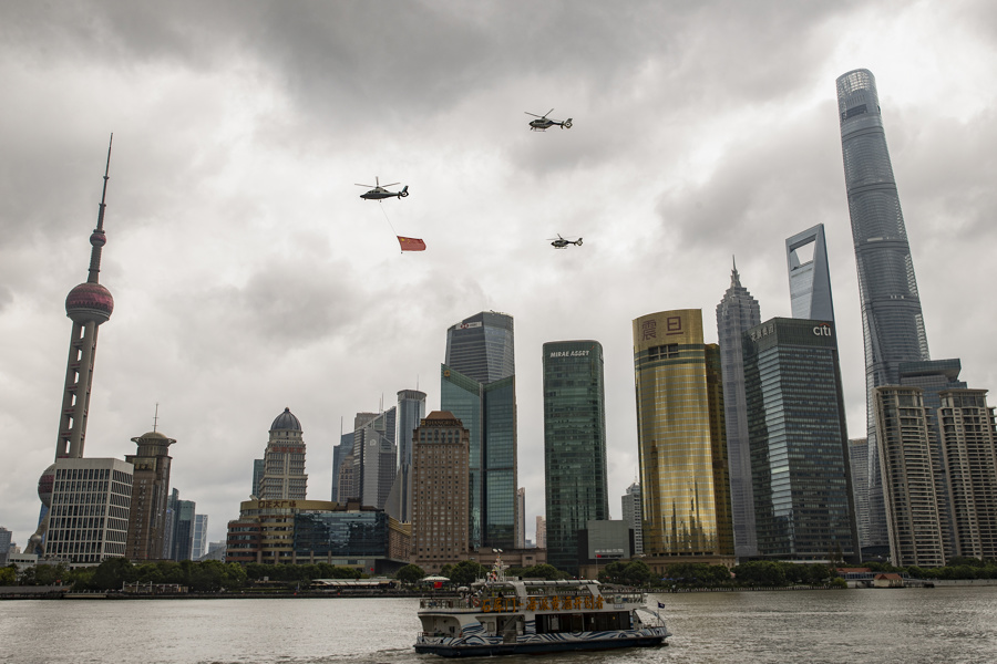警用直升机悬挂五星红旗，在黄浦江上空环绕飞行，吸引众多市民游客挥手致意.jpeg