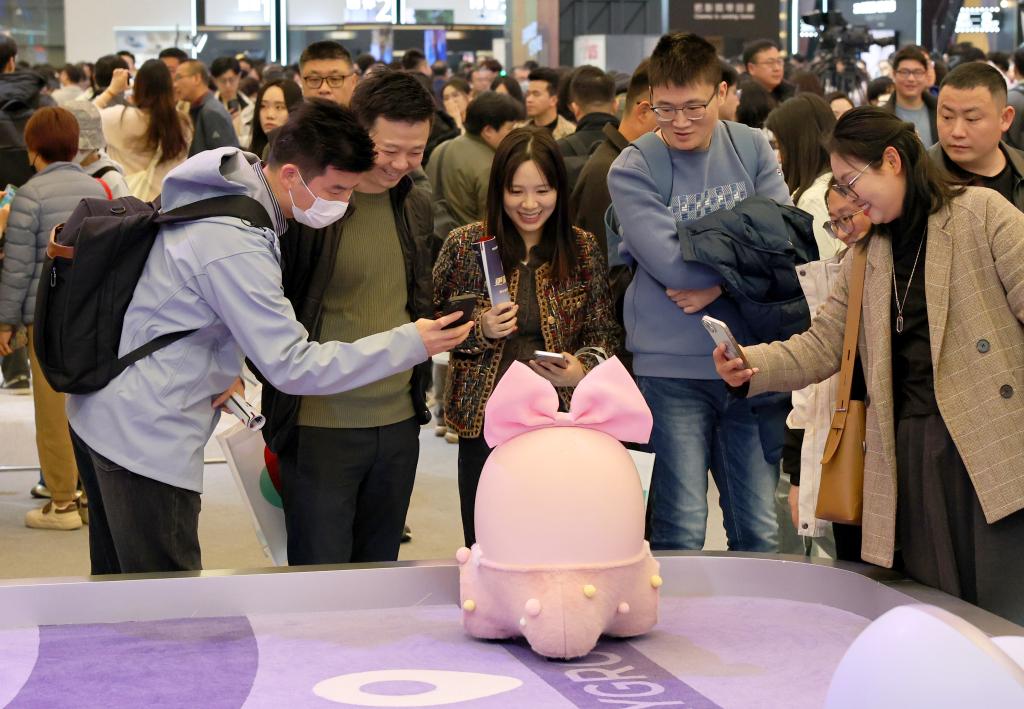 3月20日,参观者在展会上与“Ai Me智能机器人”互动。.jpeg 3月20日,参观者在展会上与“Ai Me智能机器人”互动。.jpeg