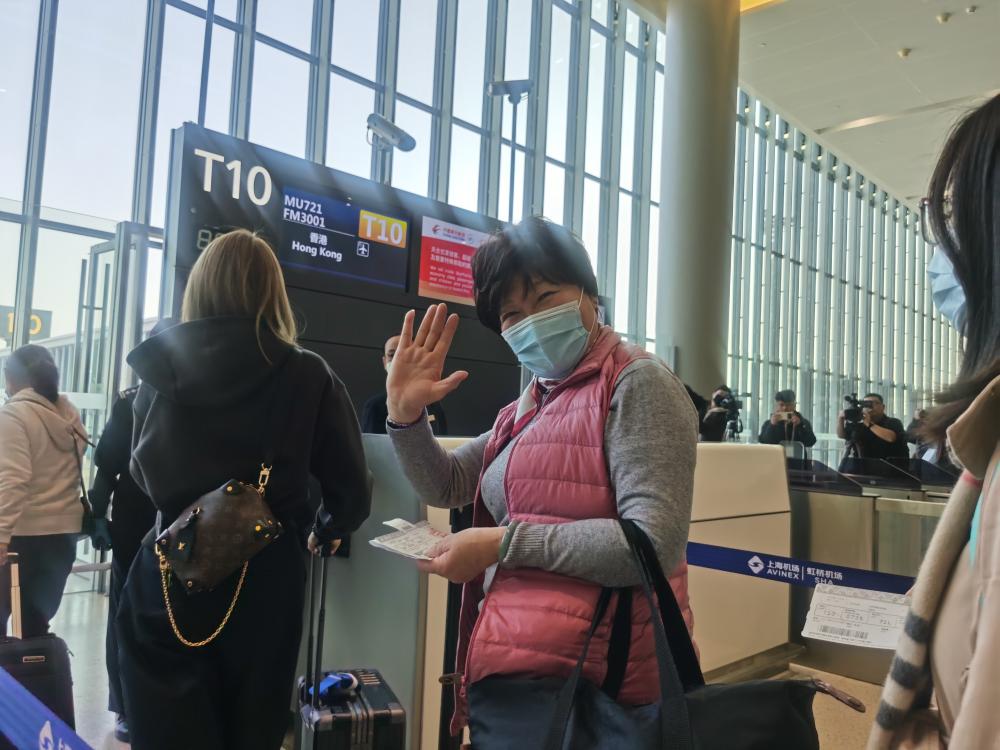 昨天，虹桥机场国际和港澳台航线复航后首个出港航班，70岁的何阿姨准备登机前往香港.jpeg