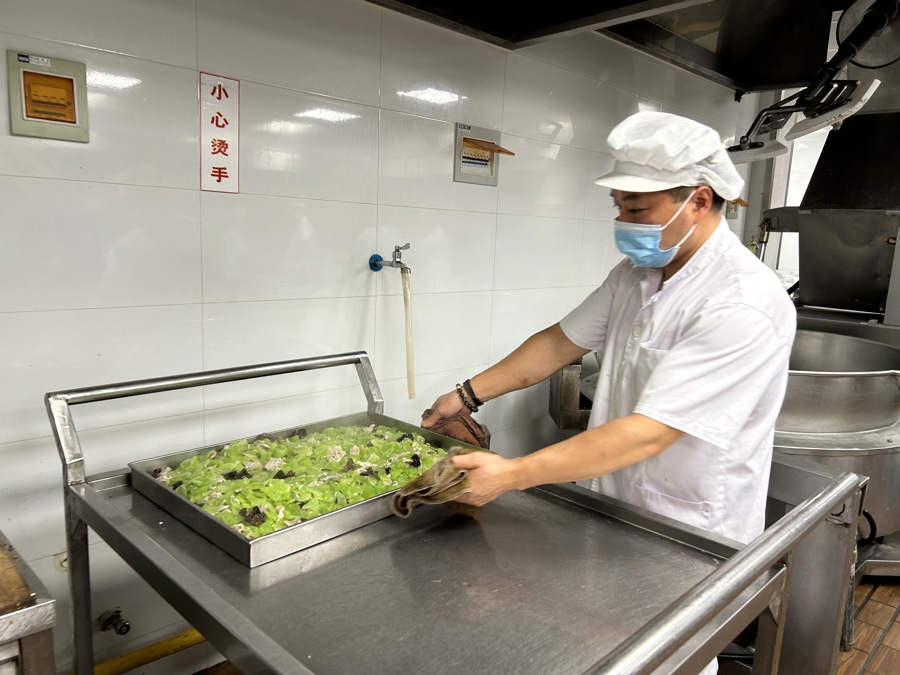 配餐人员正端出荤素搭配的菜.jpeg 配餐人员正端出荤素搭配的菜.jpeg