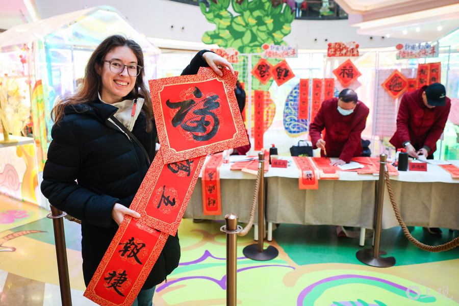 来自德国的游客展示自己心仪的春联和福字.jpg