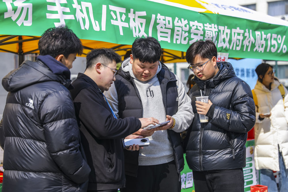 2025年3月6日,学生在山东省青岛恒星科技学院开展的消费品以旧换新活动中选购手机。(张鹰 摄).jpeg
