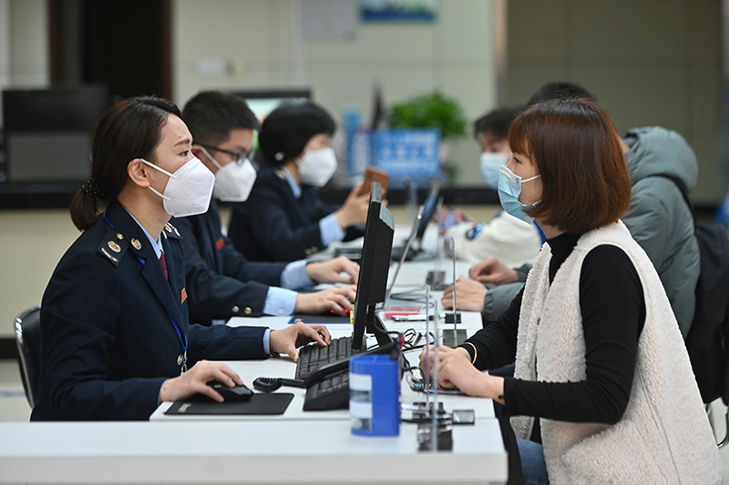在福州市闽清县办税服务大厅，工作人员向企业工作人员介绍税惠政策（2023年2月13日摄）。.JPG