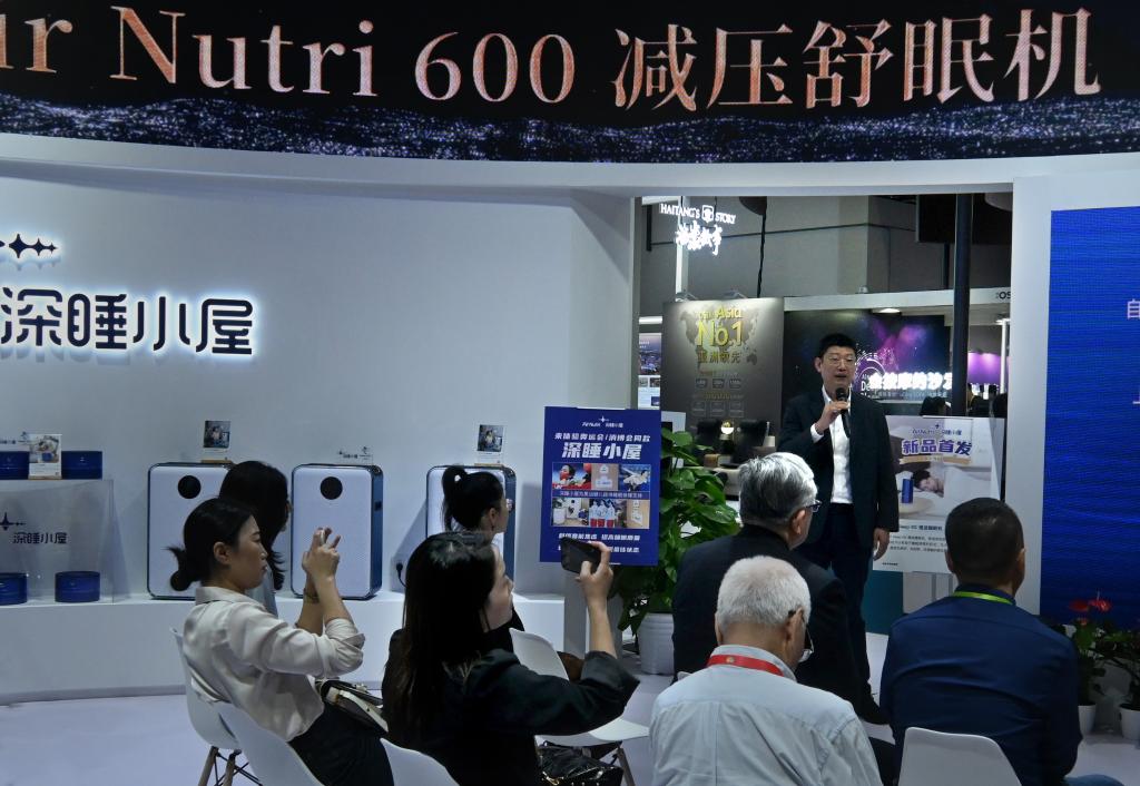 4月13日，在消博会1号馆艾纳诗展区，参展商向人们介绍产品。（王颂 摄）.jpg