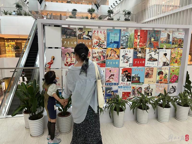 一对母女在《少年文艺》封面墙前驻足.jpeg 一对母女在《少年文艺》封面墙前驻足.jpeg